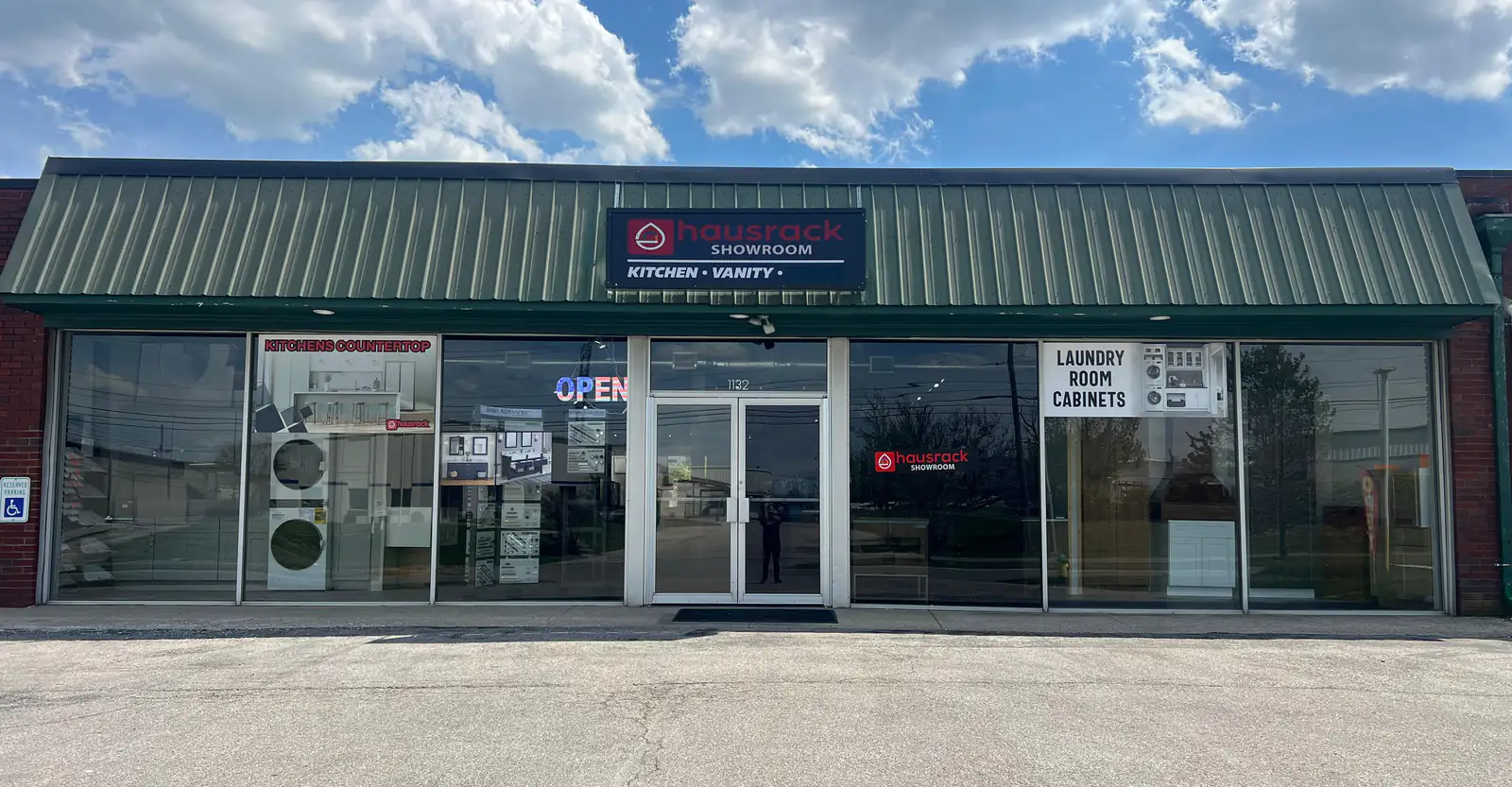 The HausRack Lexington showroom at 1132 Industry Rd: a green metal roof over glass shop windows and a lit hausrack showroom sign