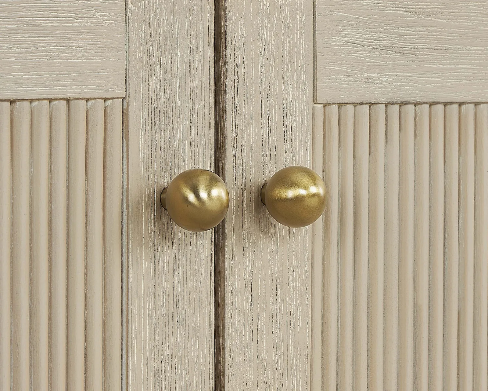Close-up of the fluted doors and round brass knobs